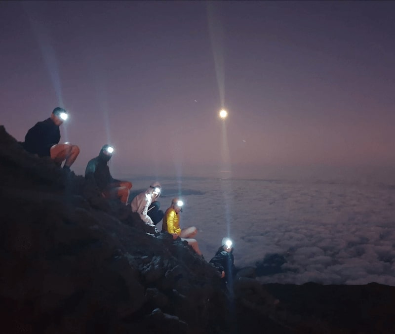 group people climbing pico at night